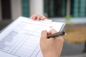person holding clipboard with pen